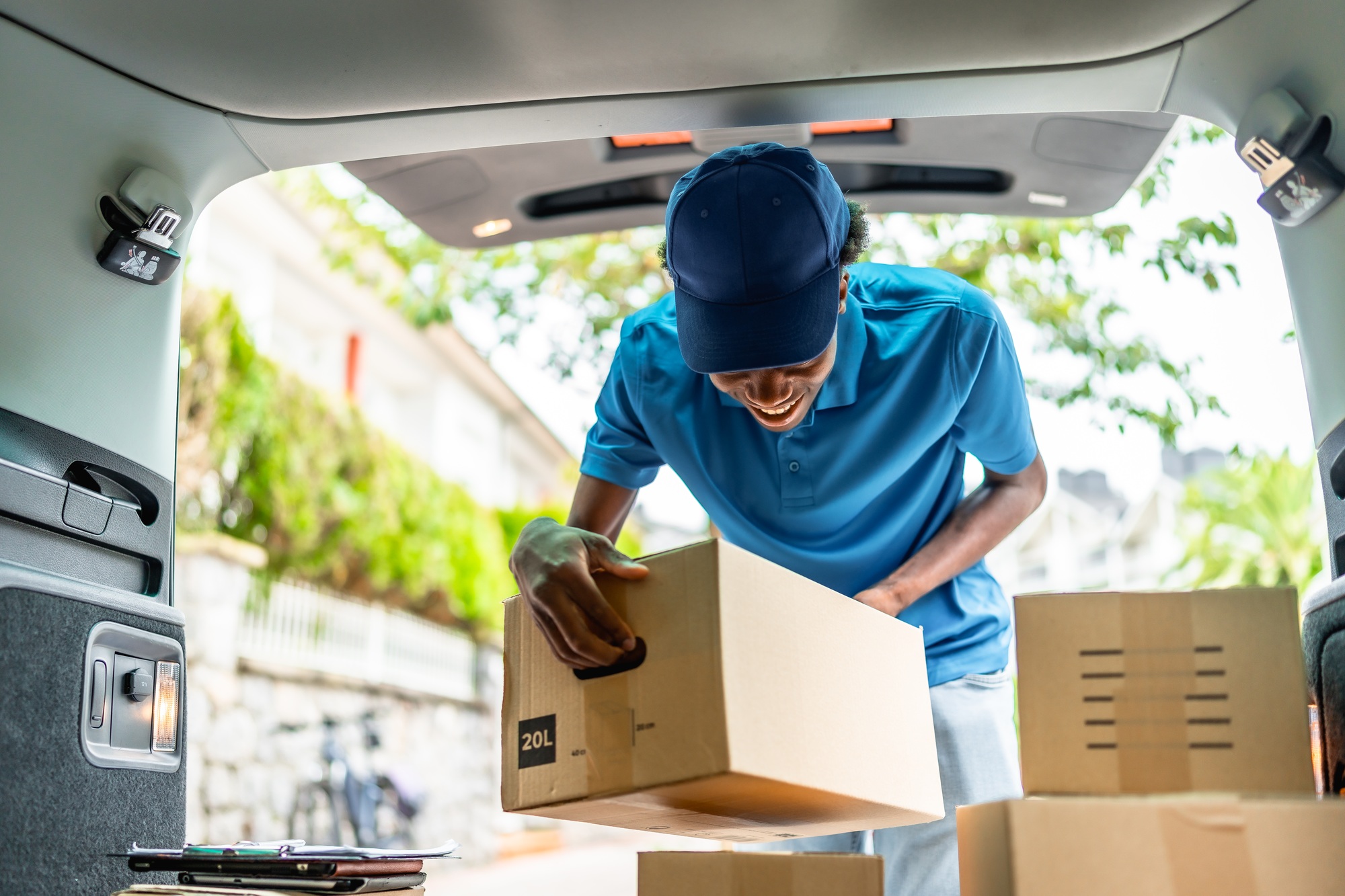 Delivery african man working with several packages on van